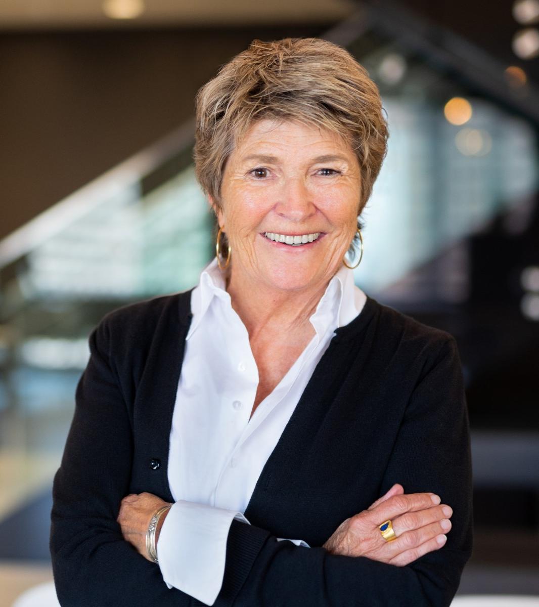 white woman with blond short hair with black sweater and white collared shirt